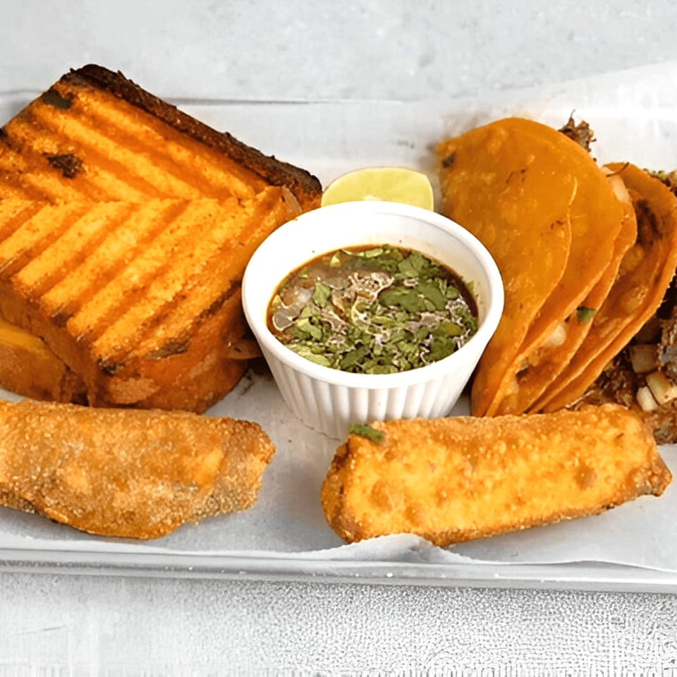 Smack'n Tacos birria tacos, grilled cheese, and egg rolls with a side of consommé.